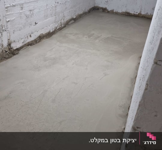 רצפת בטון חלקה בחדר עם קירות לבנים